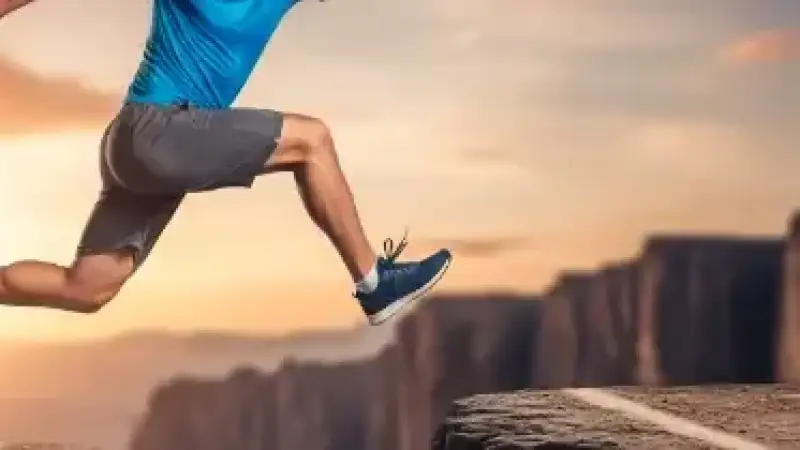 Eine Person arbeitet an einem Laptop und hält ihren Lebenslauf – Symbol für Karriereentwicklung durch Zeitarbeit